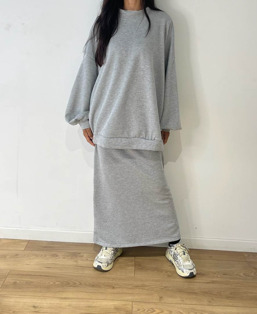 Femme portant un ensemble jupe et pull en coton gris