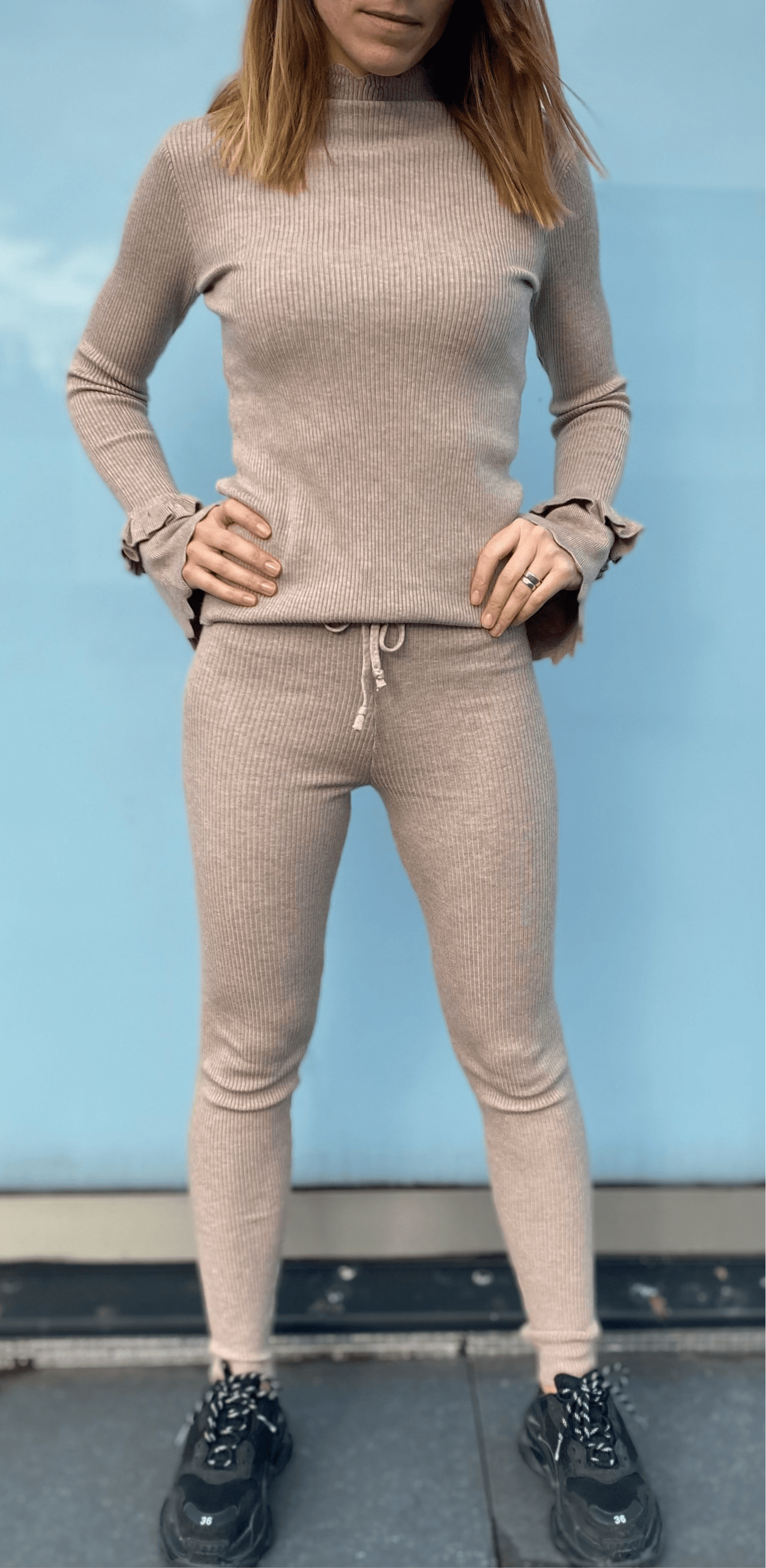 Vue complète d'une femme portant un ensemble haut et leggings taupe