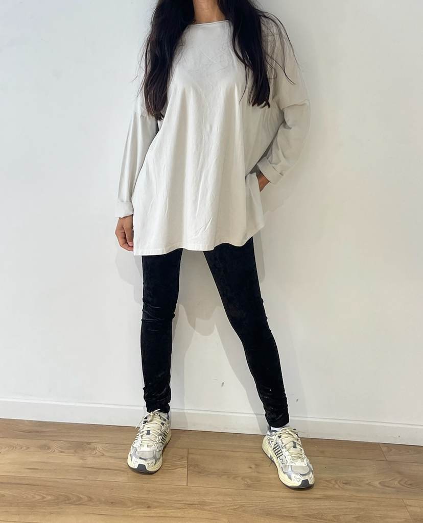 Femme portant un haut blanc oversize avec jeans noirs