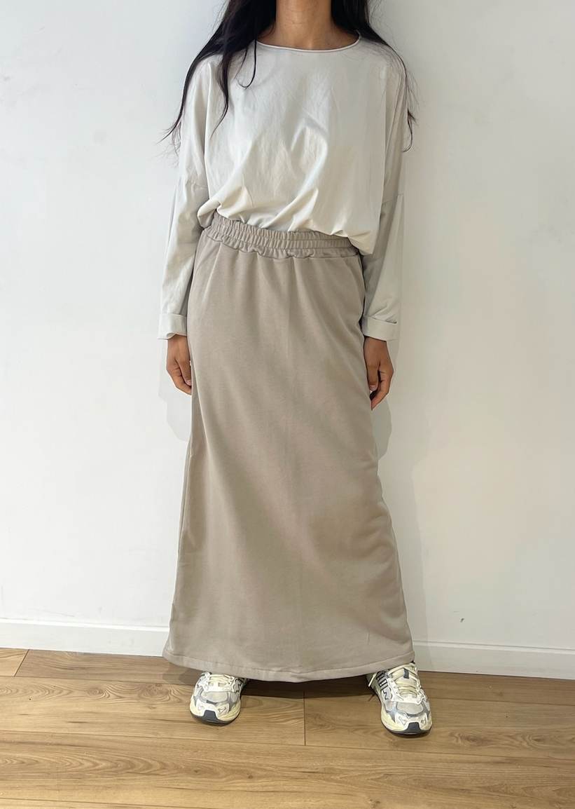 Femme stylée en jupe longue taupe et haut oversize blanc
