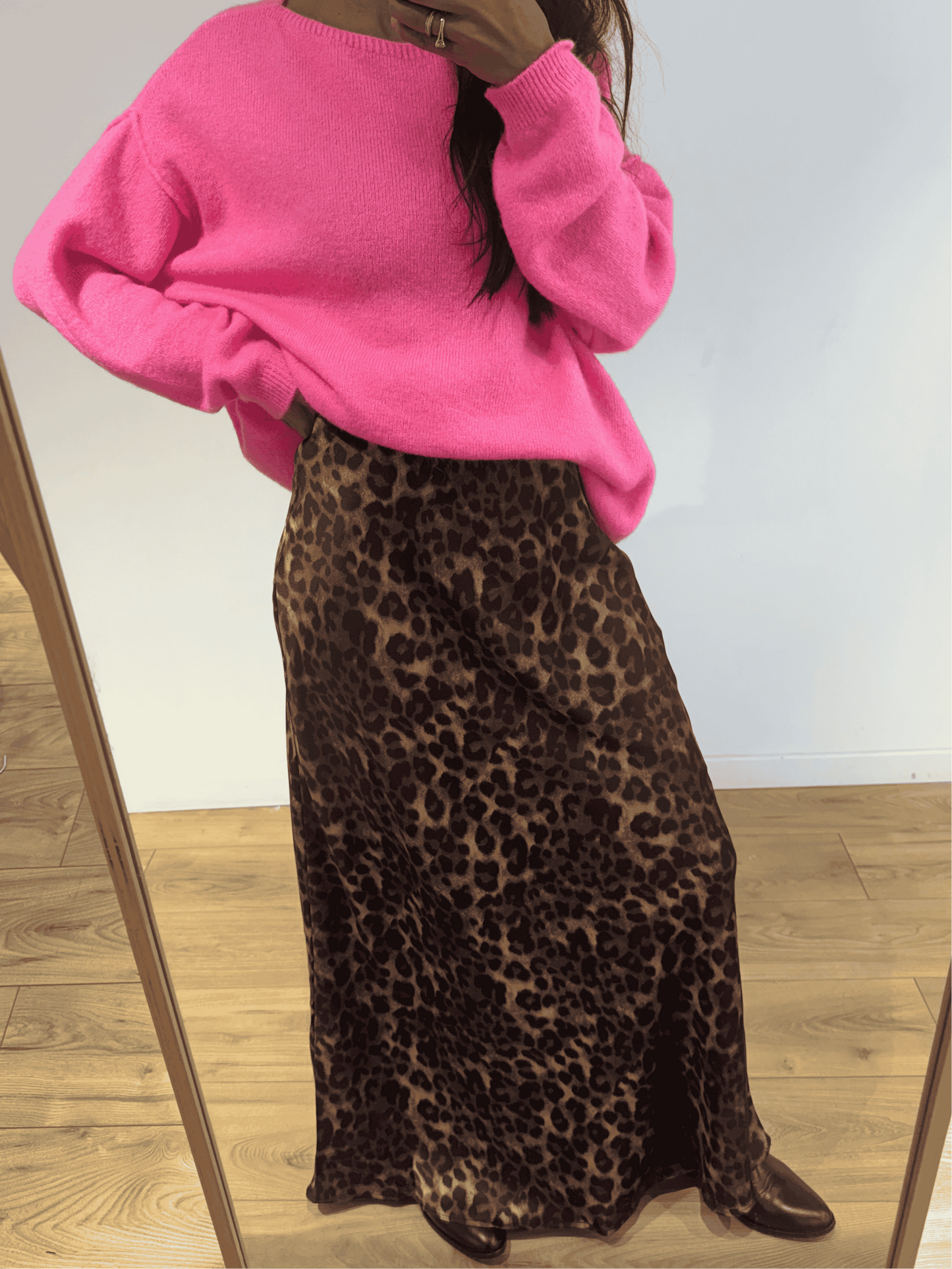 Femme portant une jupe longue en satin imprimé léopard avec un pull rose vif