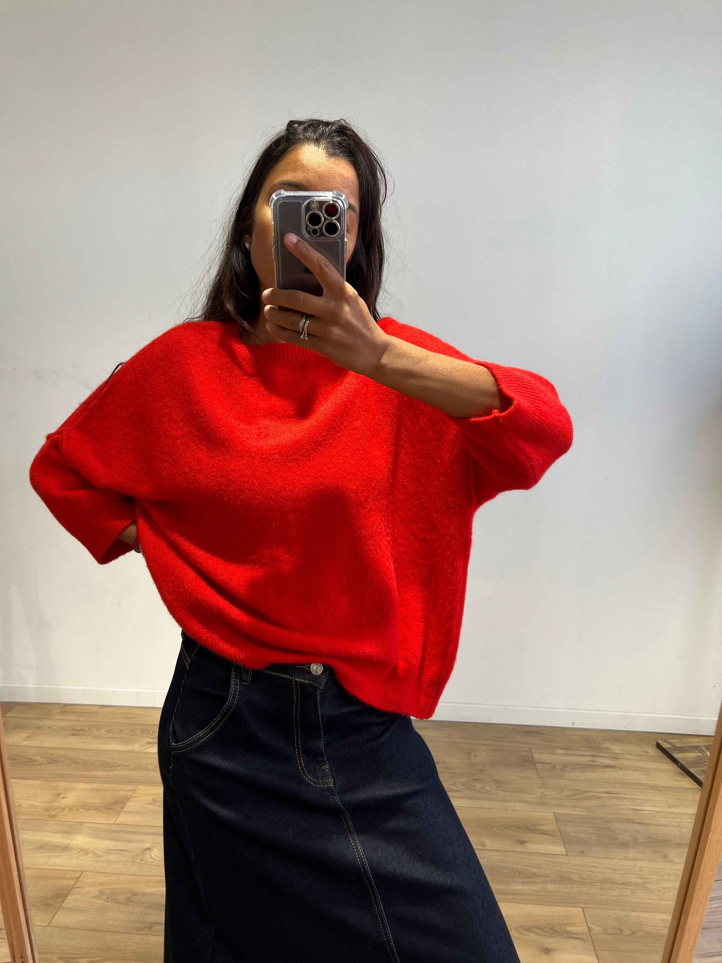 Femme portant un pull rouge en laine, style décontracté et tendance.