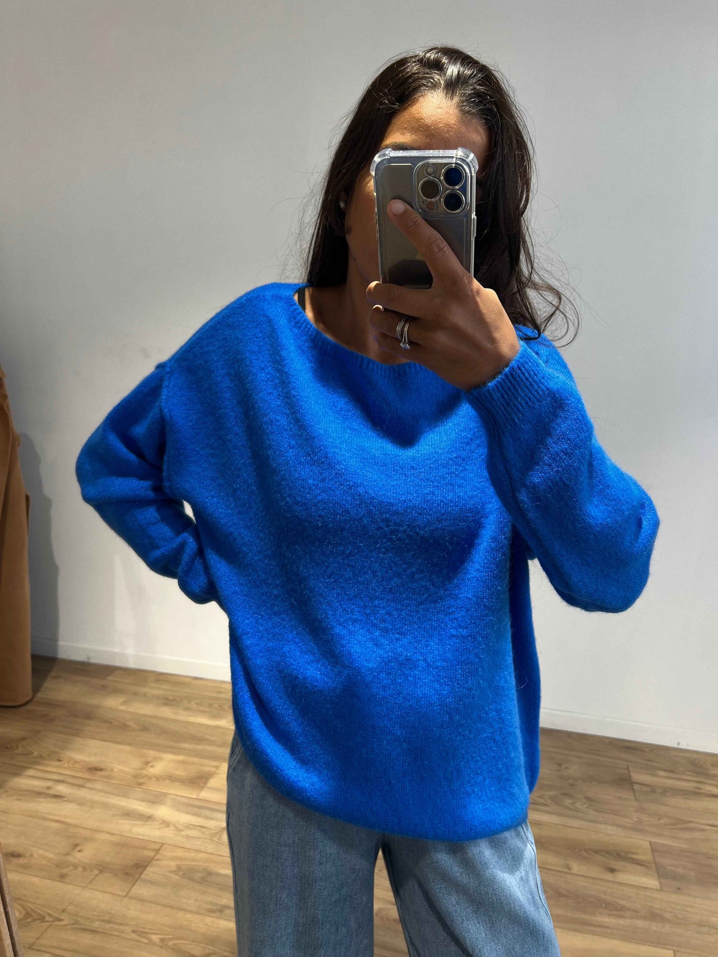 Femme portant un pull en laine bleu vif à manches longues.