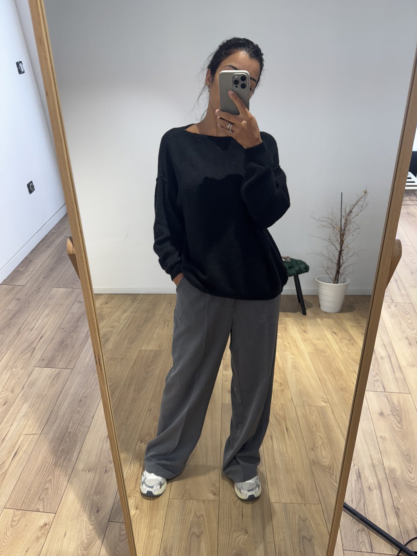 Femme portant un pull en laine noir dans un style décontracté avec un pantalon large.