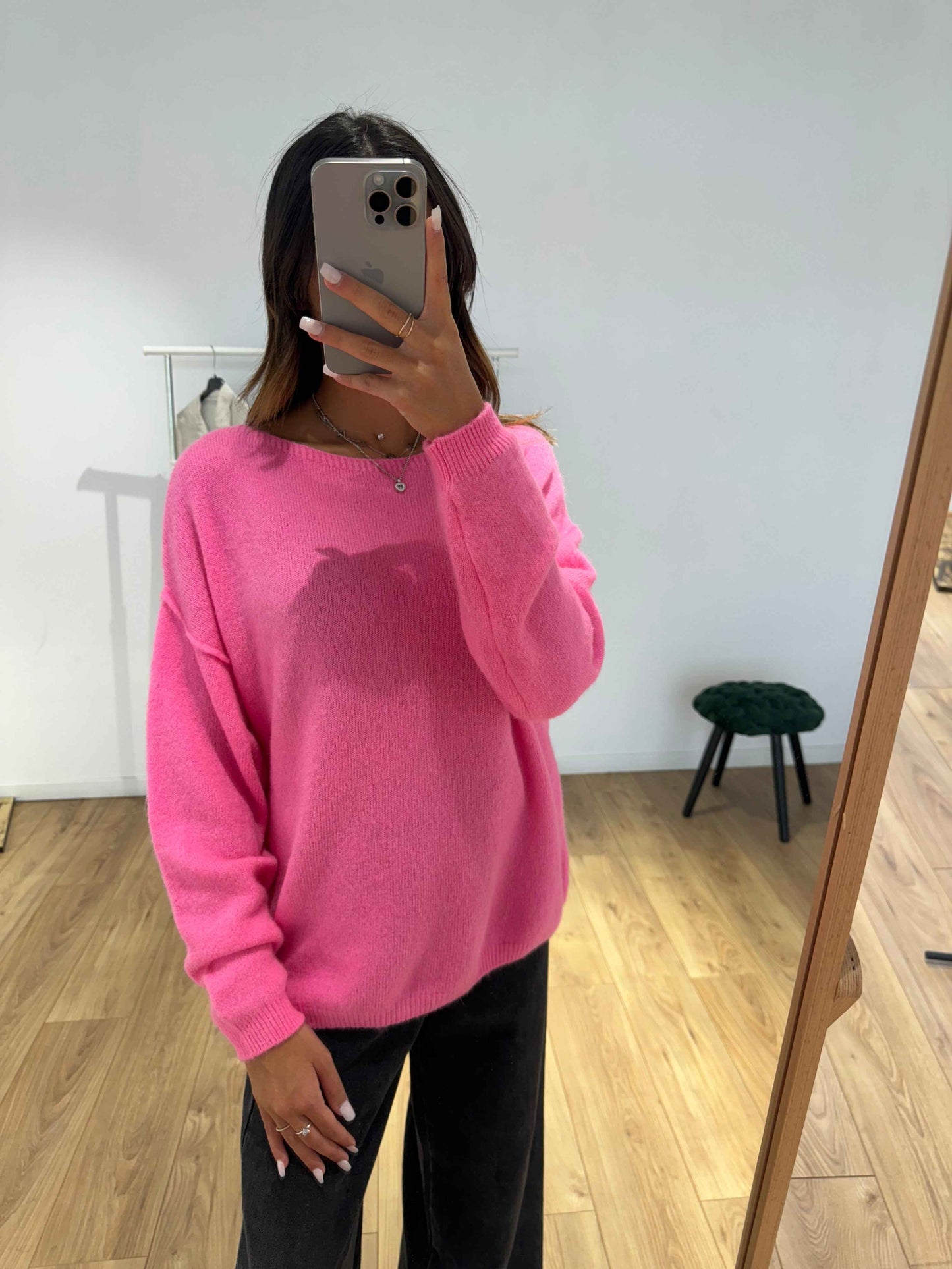 Femme prenant un selfie dans un pull en laine rose vif.