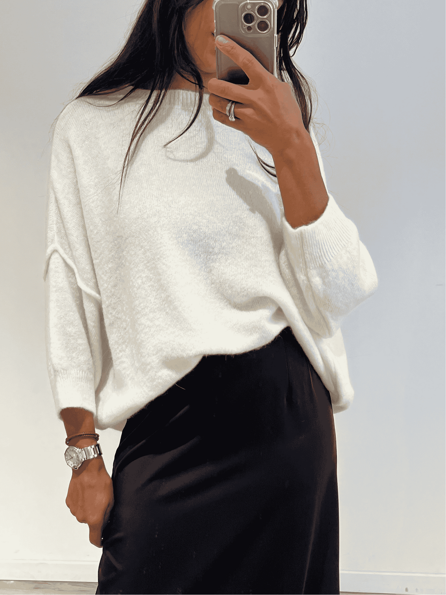 Femme portant un pull en laine blanc avec manches trois quarts, look chic et décontracté.