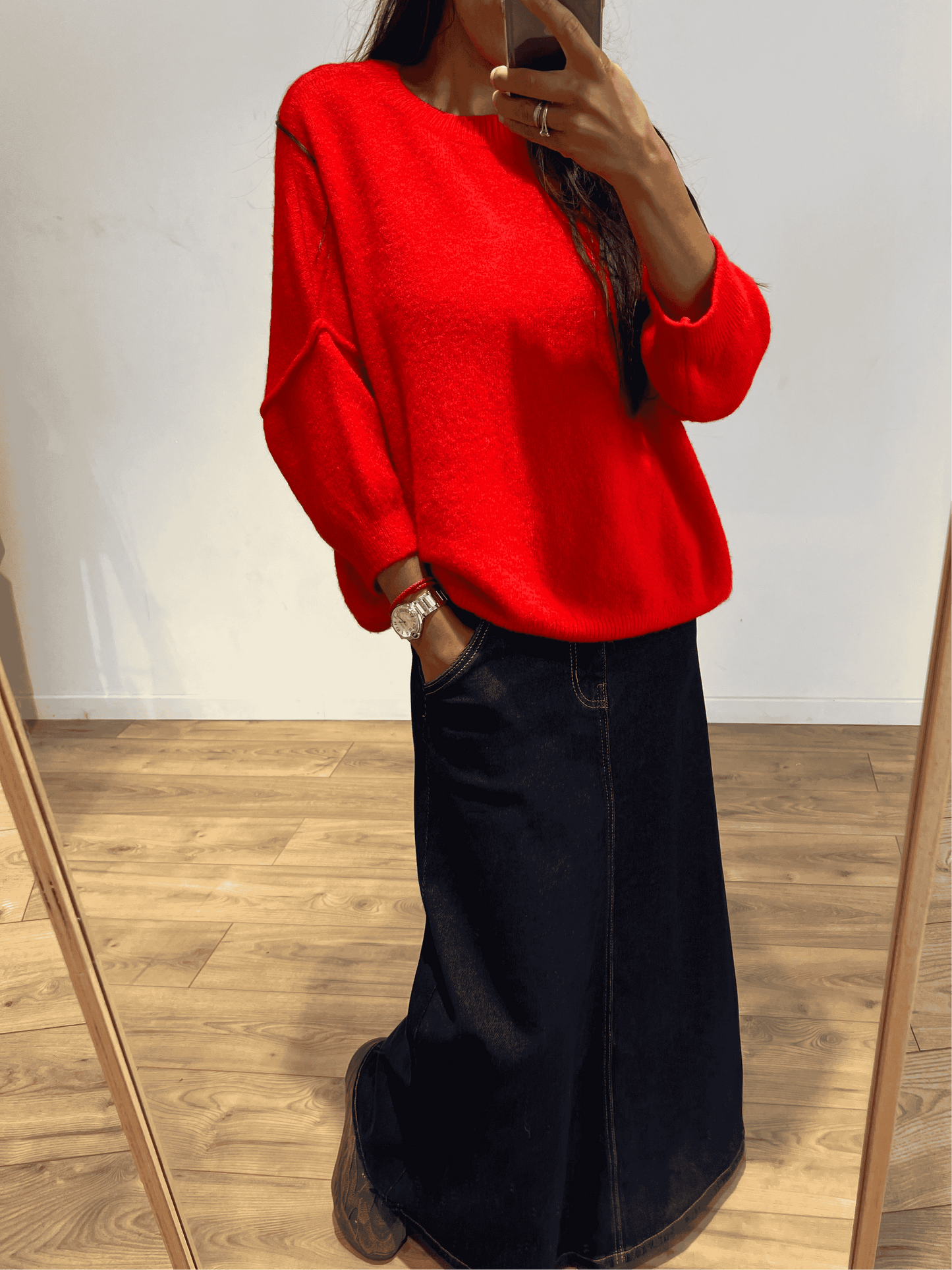 Femme en pull rouge avec manches trois quarts et jupe longue, look automnal.