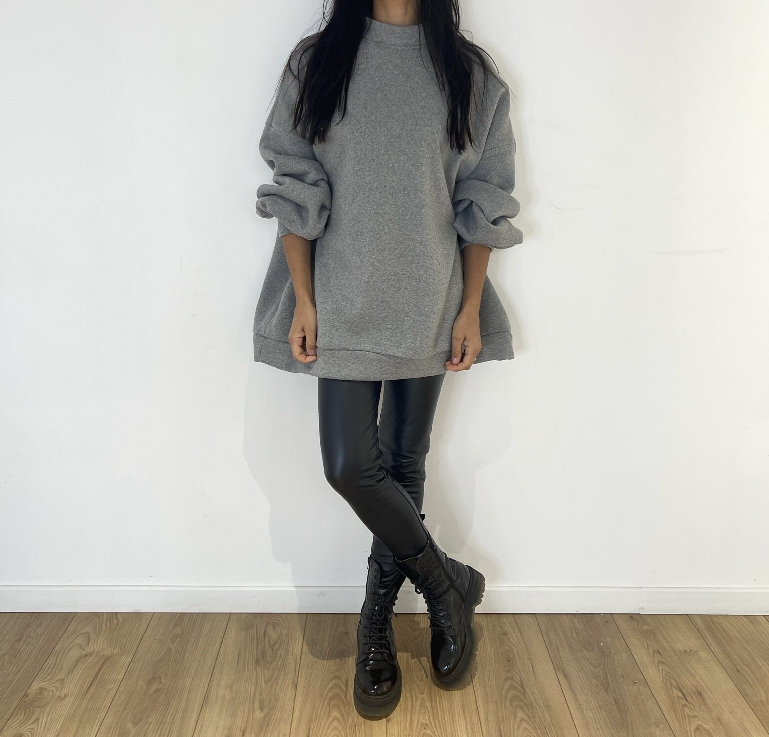 Sweat gris oversize avec legging noir pour une tenue contemporaine