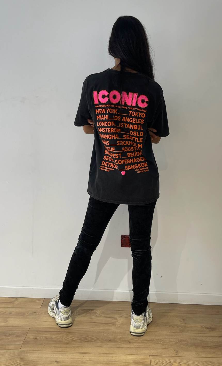 Vue arrière du t-shirt noir femme avec impression "ICONIC" et noms de villes